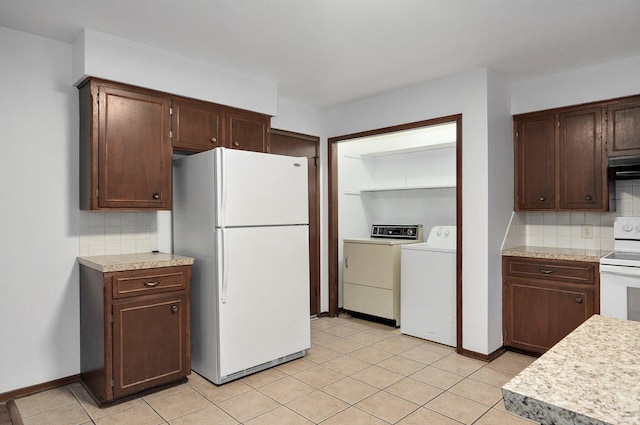 kitchen with light countertops, white appliances, washing machine and clothes dryer, and decorative backsplash