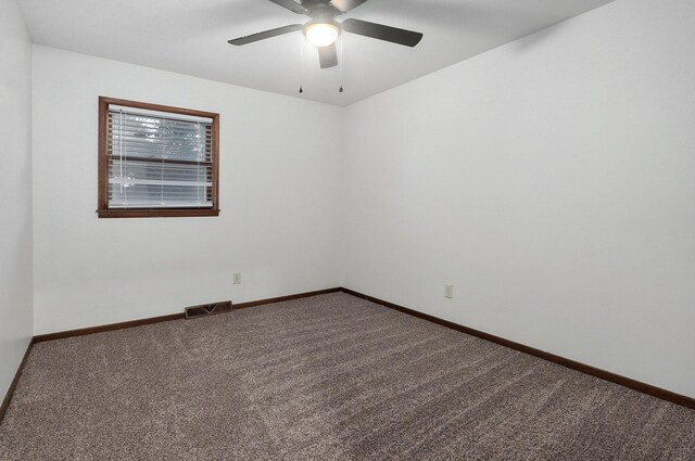 carpeted spare room with ceiling fan, visible vents, and baseboards