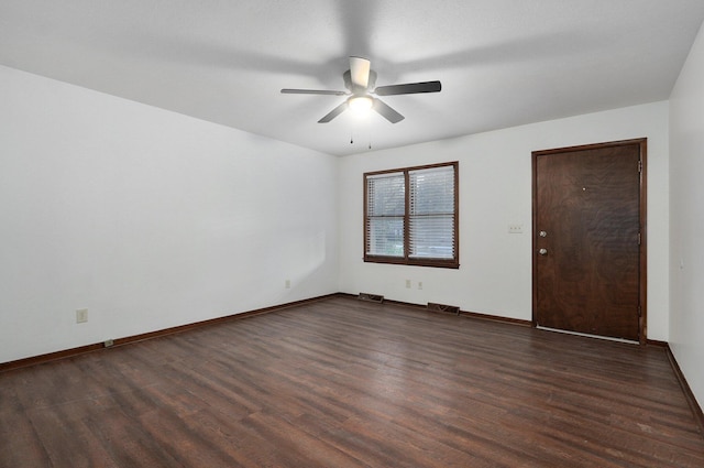 unfurnished room with dark wood-style floors, ceiling fan, visible vents, and baseboards