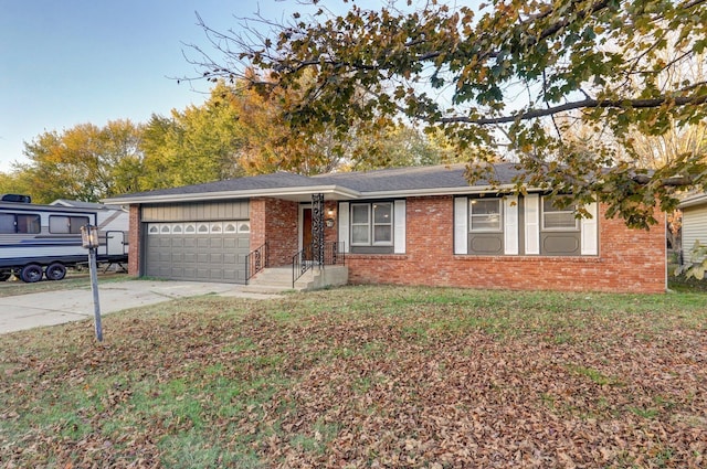 ranch-style home with a garage, a front yard, concrete driveway, and brick siding