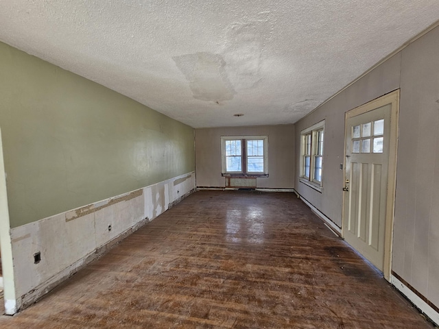 empty room with a textured ceiling and wood finished floors