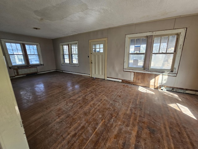 entrance foyer with a textured ceiling, baseboards, and wood finished floors