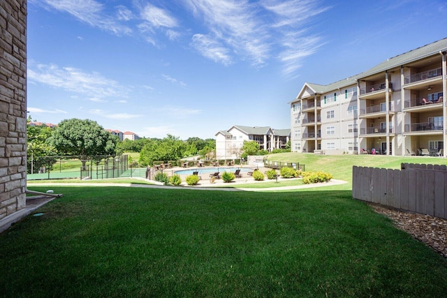 view of yard with fence and a community pool