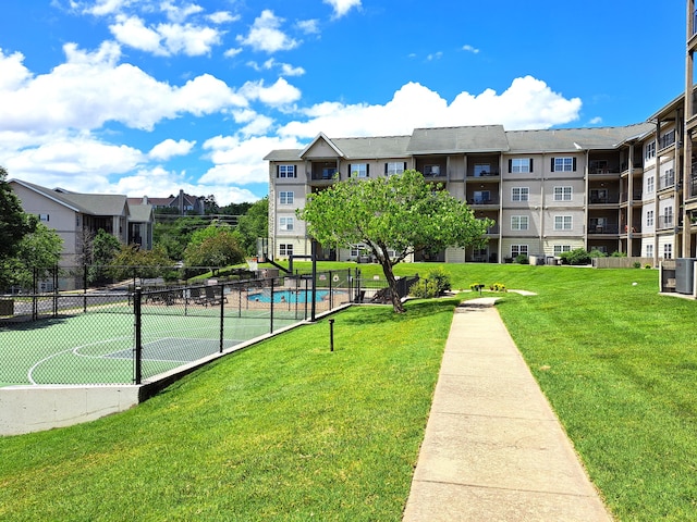 surrounding community with fence and a lawn