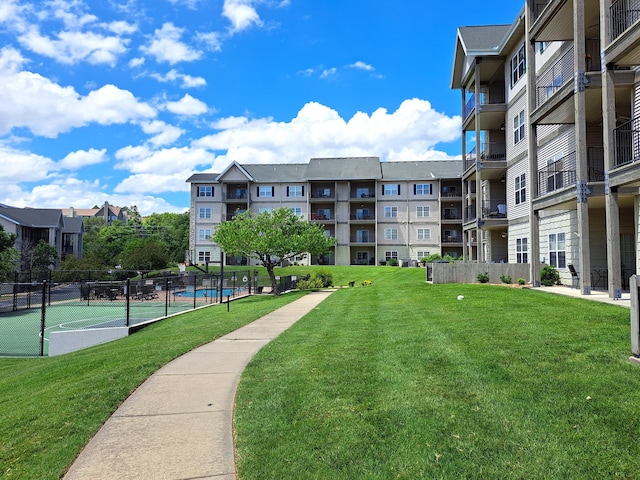 view of community featuring a lawn and fence