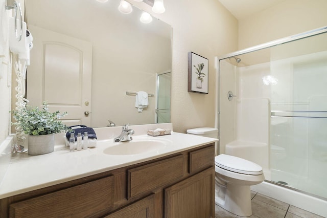 bathroom featuring toilet, a stall shower, tile patterned flooring, and vanity