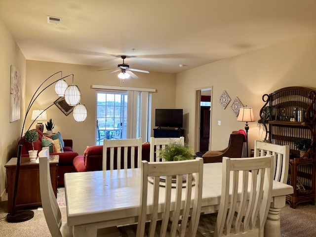 carpeted dining area featuring visible vents and a ceiling fan