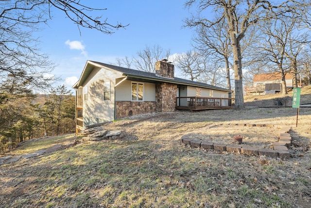 view of front of property with a chimney, stone siding, and a deck