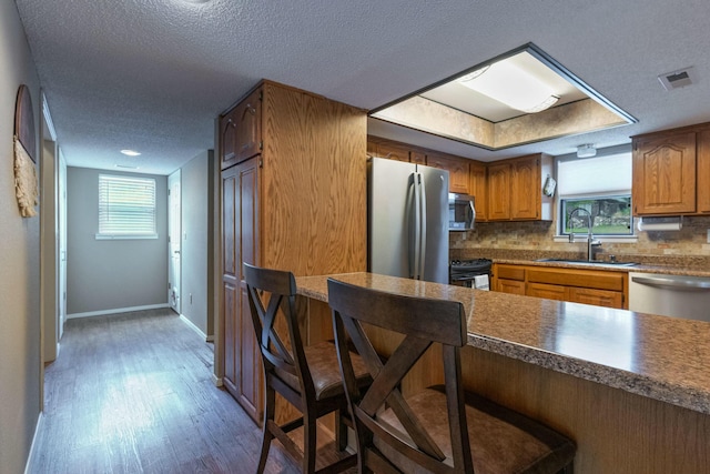 kitchen with stainless steel appliances, visible vents, a sink, and tasteful backsplash