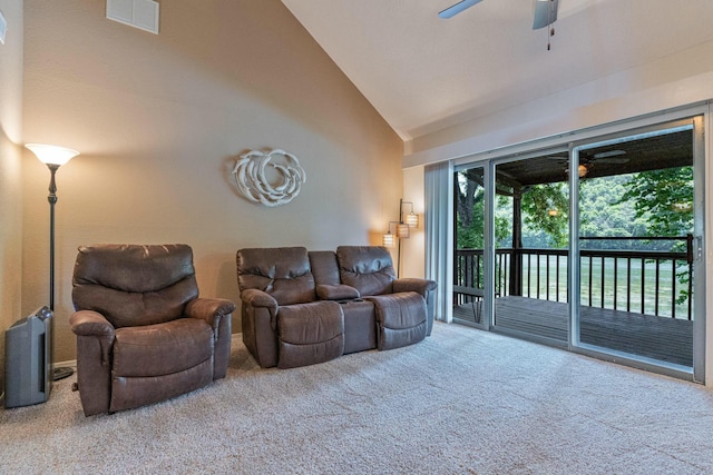 carpeted living area with high vaulted ceiling, visible vents, and a ceiling fan