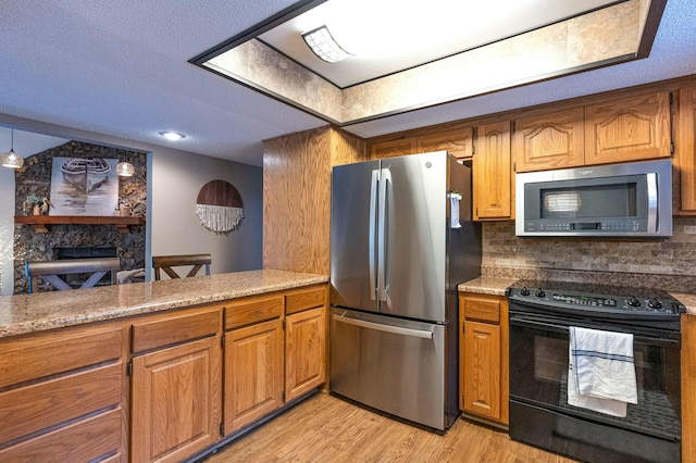 kitchen with light countertops, appliances with stainless steel finishes, light wood-type flooring, brown cabinets, and decorative backsplash