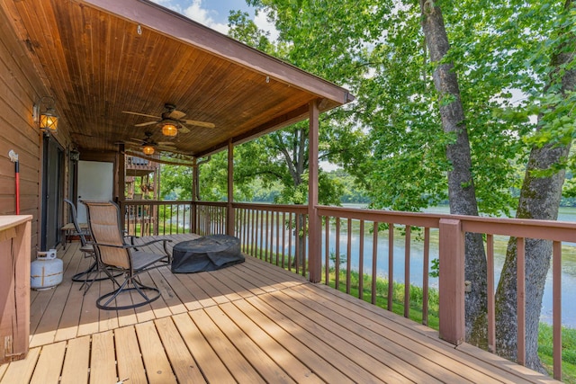 deck with ceiling fan and a water view