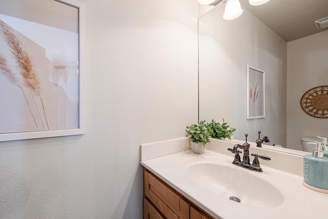 half bathroom featuring visible vents and vanity