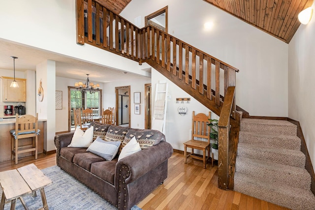 living room with light wood finished floors, stairs, high vaulted ceiling, and a chandelier