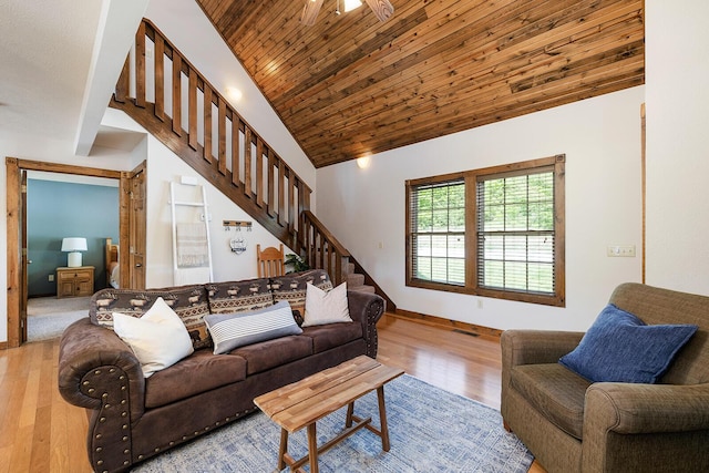 living area with baseboards, wood ceiling, wood finished floors, stairs, and vaulted ceiling