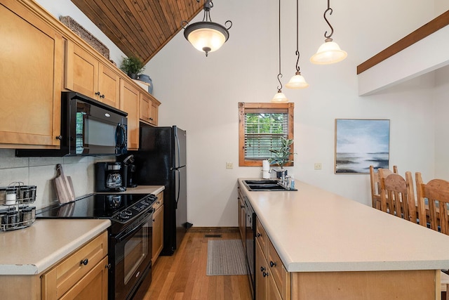 kitchen featuring black appliances, tasteful backsplash, light countertops, and a sink