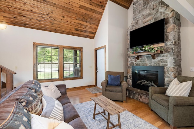 living room with a fireplace, wood ceiling, wood finished floors, high vaulted ceiling, and baseboards