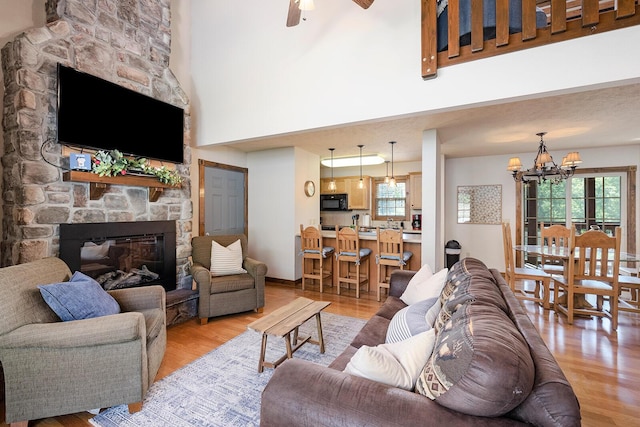 living room featuring light wood-type flooring, a healthy amount of sunlight, a fireplace, and baseboards