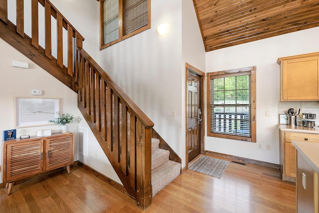 entryway featuring stairway, light wood-type flooring, wooden ceiling, and baseboards