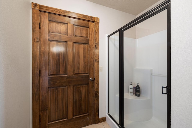 bathroom featuring a stall shower, a textured ceiling, and tile patterned floors