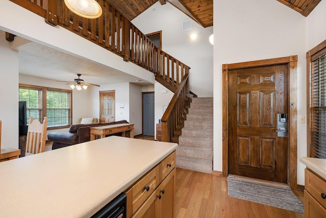 foyer entrance with visible vents, stairway, light wood-style flooring, wood ceiling, and high vaulted ceiling