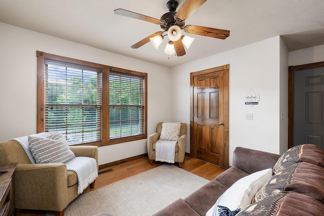 living area featuring ceiling fan, wood finished floors, and baseboards