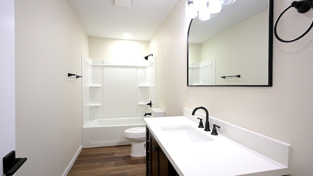 bathroom with baseboards, toilet, wood finished floors,  shower combination, and vanity