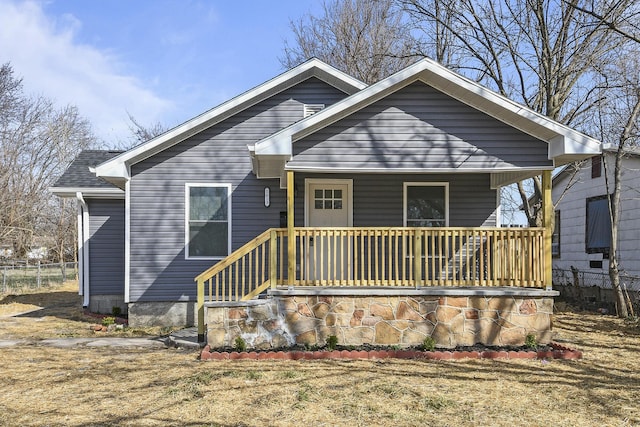 bungalow-style house featuring a porch and roof with shingles