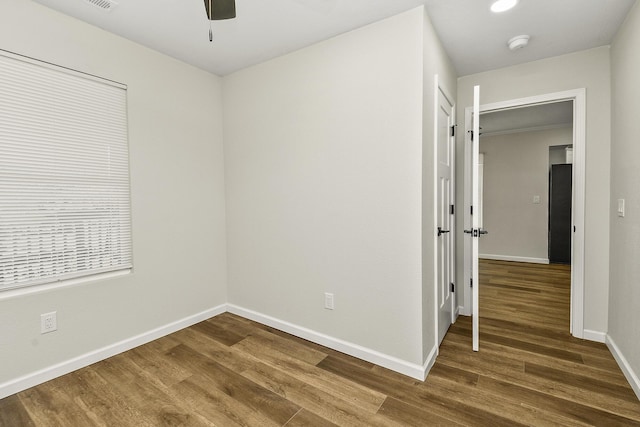 unfurnished room with ceiling fan, baseboards, and wood finished floors