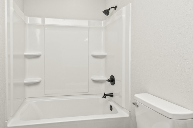 bathroom featuring a textured wall and toilet