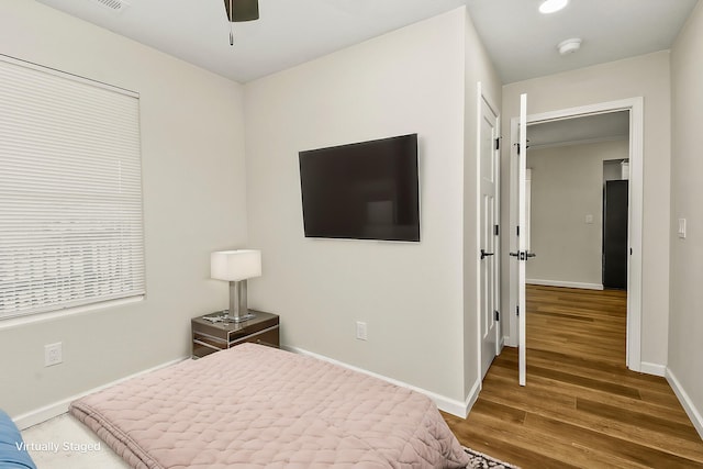 bedroom featuring wood finished floors, visible vents, and baseboards