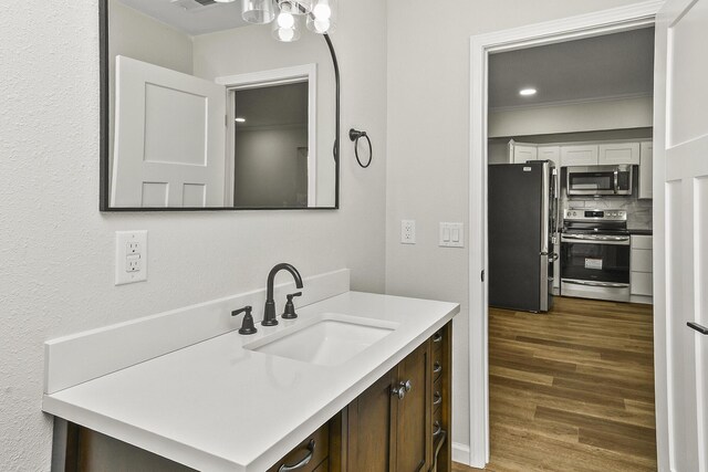 bathroom featuring visible vents, vanity, decorative backsplash, and wood finished floors