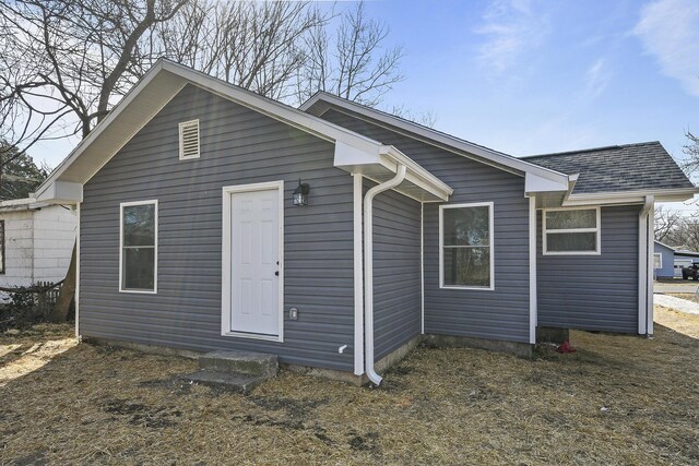 rear view of property with roof with shingles