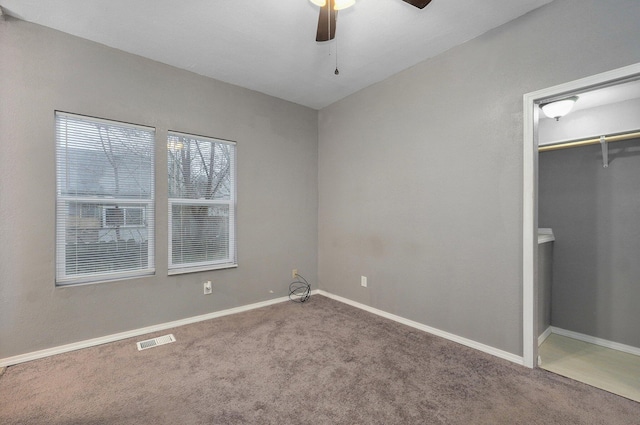 unfurnished bedroom with ceiling fan, visible vents, baseboards, a closet, and carpet