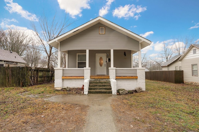 view of front of home with covered porch and fence