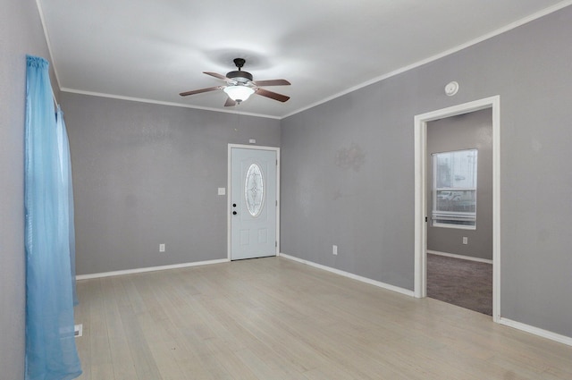 entryway featuring light wood finished floors, ceiling fan, ornamental molding, and baseboards