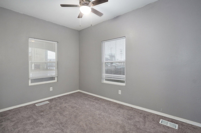 carpeted empty room with a ceiling fan, visible vents, and baseboards