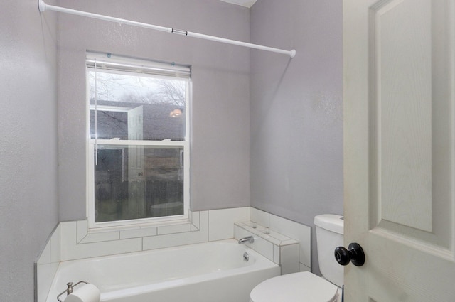 bathroom with a garden tub and toilet