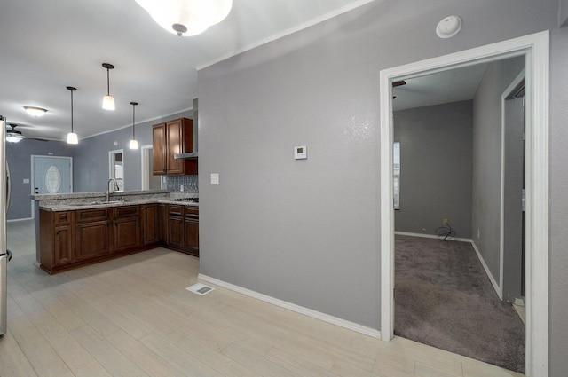 kitchen featuring baseboards, tasteful backsplash, decorative light fixtures, and a ceiling fan