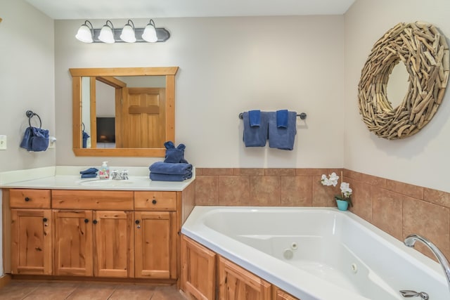 full bathroom with vanity, a tub with jets, and tile patterned floors