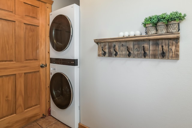 laundry area with stacked washer and dryer, light tile patterned flooring, and laundry area