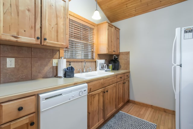 kitchen featuring tasteful backsplash, lofted ceiling, light countertops, a sink, and white appliances