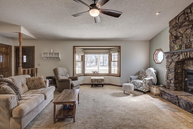 carpeted living area with a ceiling fan, a textured ceiling, and baseboards