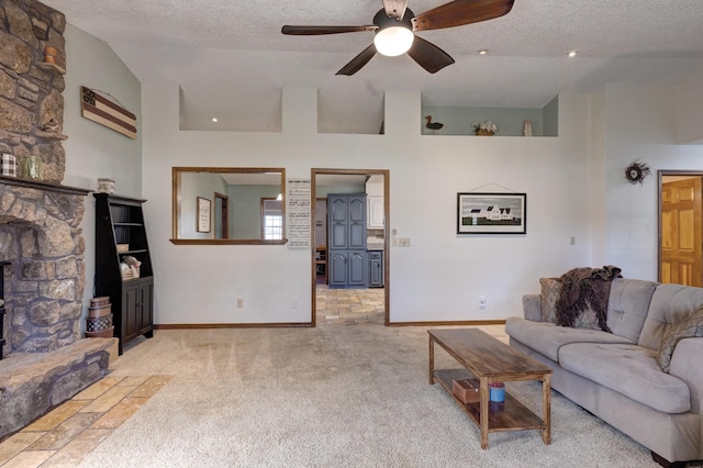 carpeted living room with high vaulted ceiling, a stone fireplace, and a textured ceiling