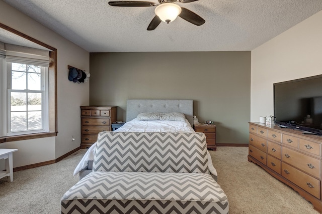 bedroom with ceiling fan, a textured ceiling, baseboards, and light colored carpet