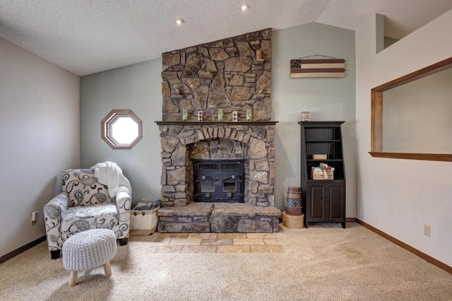 carpeted living area with baseboards, vaulted ceiling, a stone fireplace, and a textured ceiling