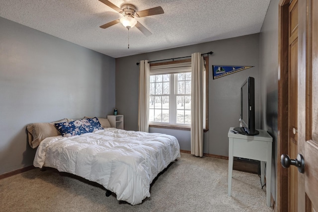 bedroom featuring light colored carpet, ceiling fan, a textured ceiling, and baseboards