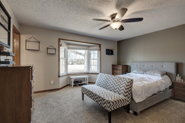 carpeted bedroom with a ceiling fan, baseboards, and a textured ceiling