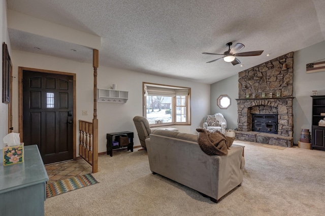 living room with ceiling fan, a textured ceiling, a fireplace, carpet flooring, and vaulted ceiling