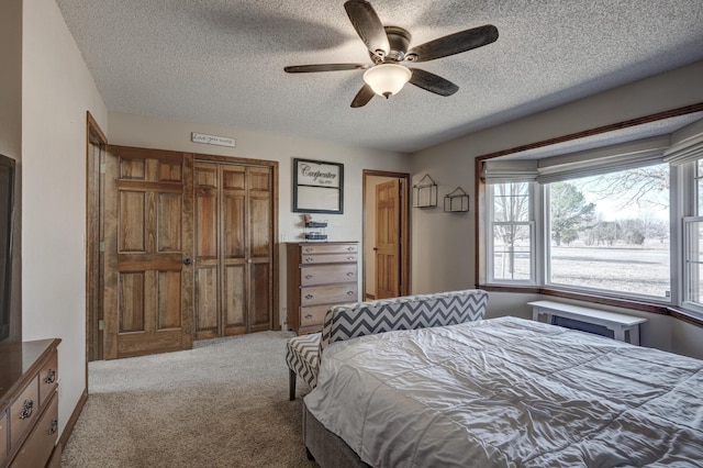 carpeted bedroom featuring a textured ceiling, a ceiling fan, and a closet